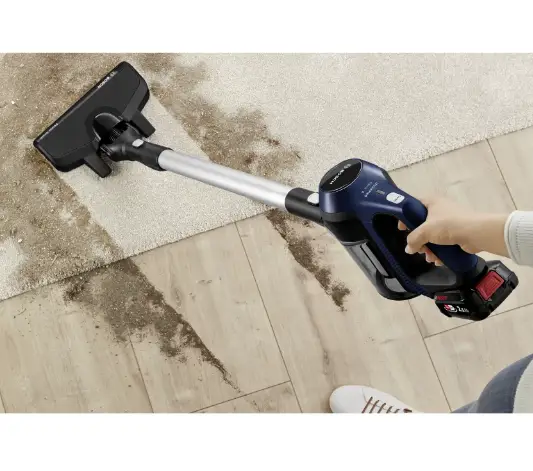 فرد با جارو شارژی بوش مدل BCS611P4A خاک روی زمین و روی موکت را جمع میکند