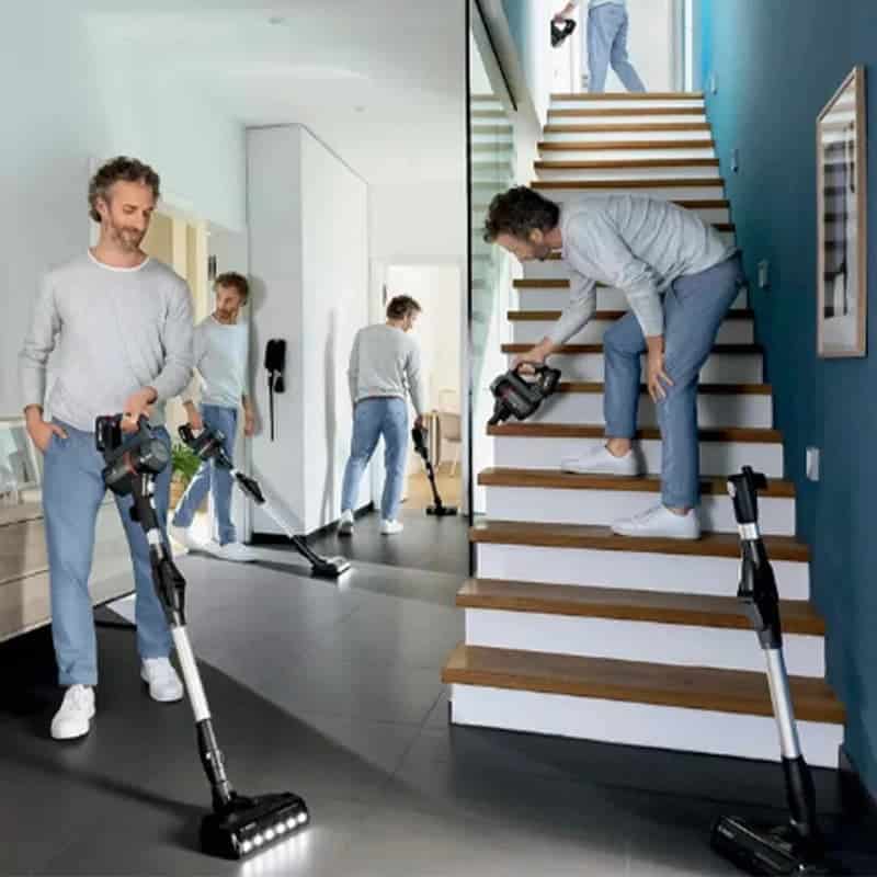 جاروشارژی عصایی بوش مدل Bosch BCS711GB در دست یک مرد درحال جارو زدن