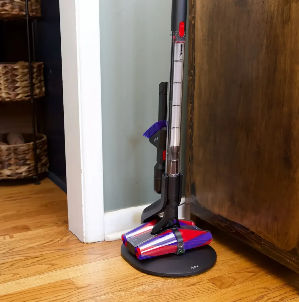 جارو شارژی دایسون مدل Pencilvac Fluffycones روی داکت شارژ رو به روی کمد چوبی رنگ