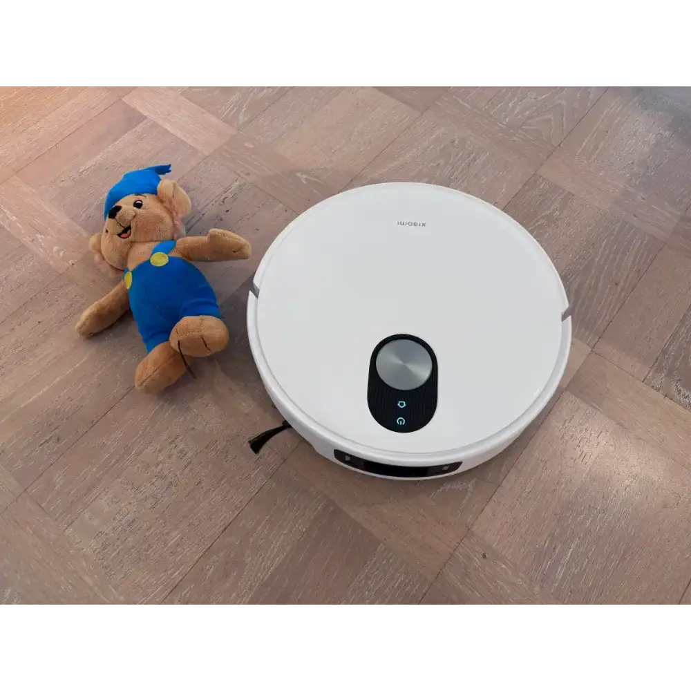 جارو رباتیک شیائومی مدل Robot Vacuum 5 Pro در کنار عروسک که در اصل نشان از برخورد نکردن ان با عروسک به دلیل تشخیص موانع است