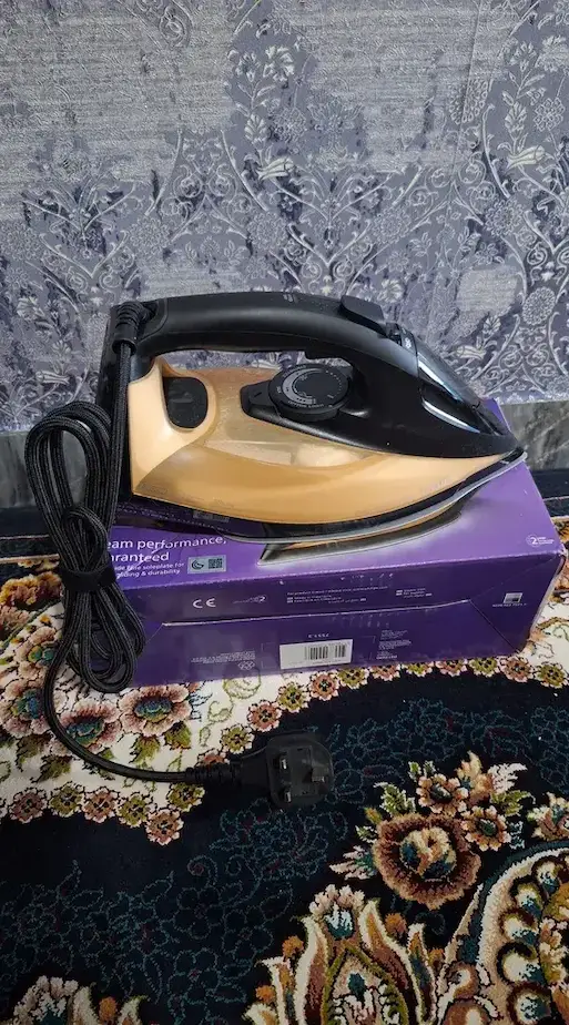 اتو بخار 2800 وات فیلیپس مدل DST7040 روی کارتون بنفش رنگ خودش