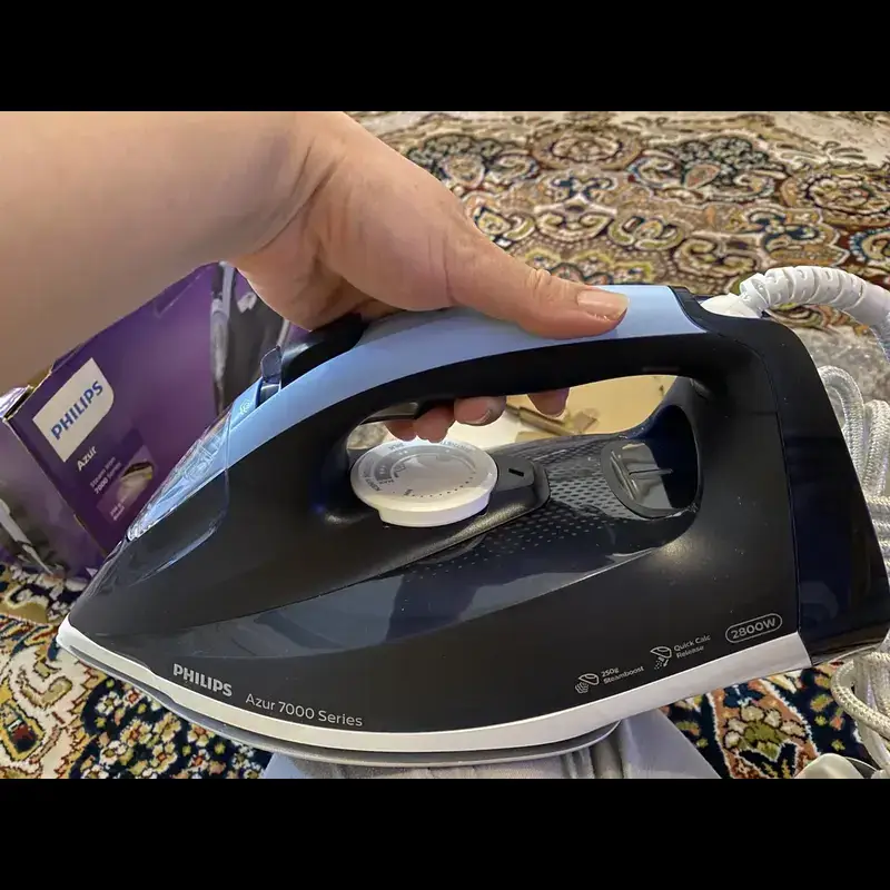 فرد اتو بخار 2800 وات فیلیپس مدل DST7030 سرمه ای رنگ را در دست گرفته است