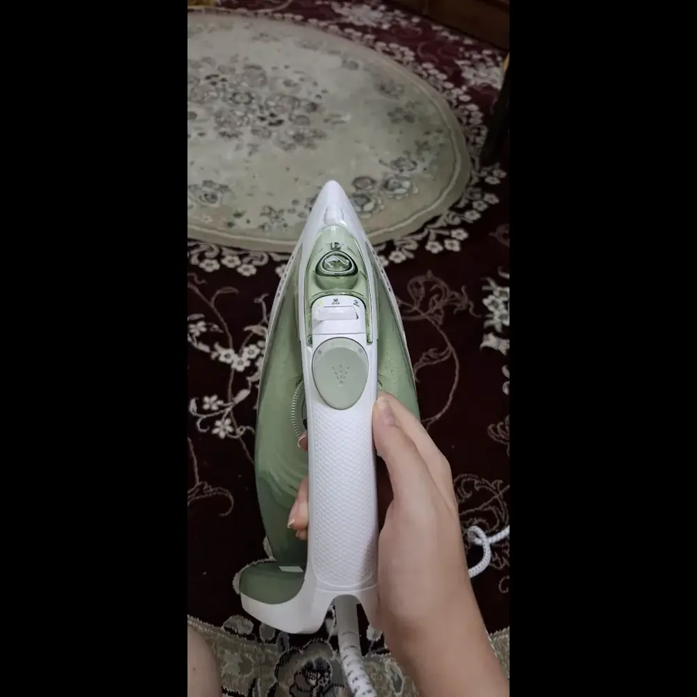 فرد اتو بخار 2800 وات تفال مدل FV5781 در دست گرفته و از نمای بالاش عکس گرفته