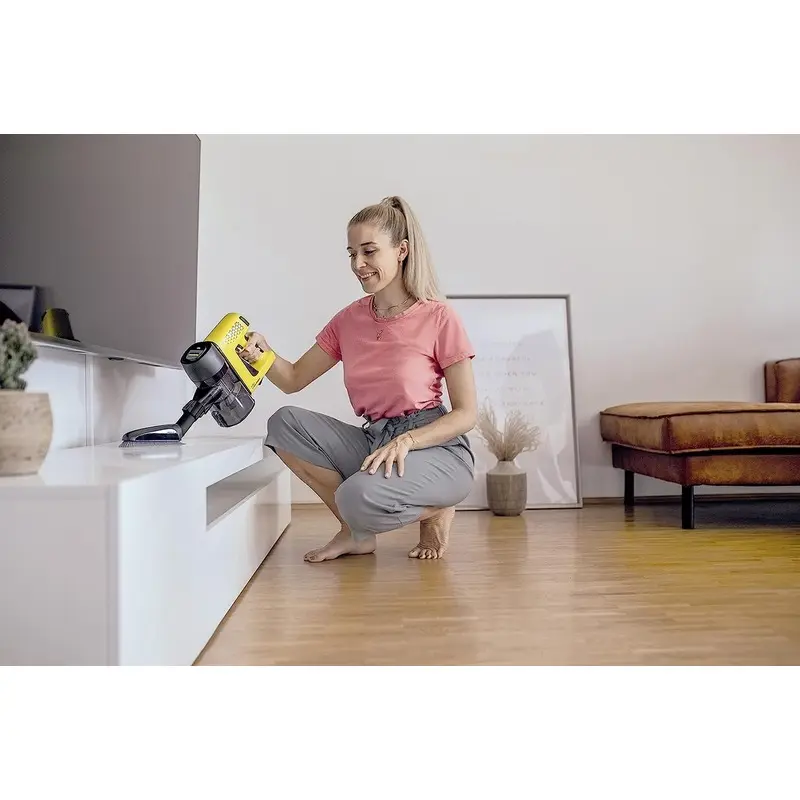 خانوم در خانه مدرن خورد با حالت دستی جاروی شارژی کارچر مدل VC 4 CORDLESS MYHOME در حالت جارو زدن است